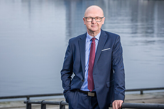 Porträt von Horst-Ulrich Stolzenberg, Vorstand für Vertrieb und Marketing bei DOMCURA, aufgenommen an der Kieler Hörn-Promenade