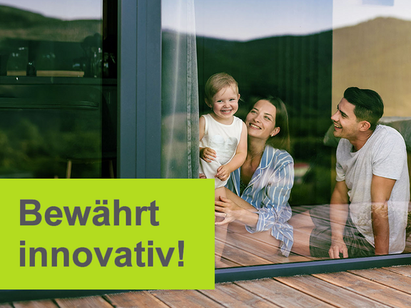Glückliche Familie mit Kind auf der Terrasse eines modernen Einfamilienhauses – Symbol für sicheres Wohnen und umfassenden Schutz durch eine Einfamilienhausversicherung; Text: ‚Bewährt innovativ!