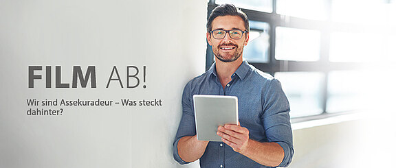 Mann mit Tablet steht lächelnd vor einem Fenster, daneben der Text: 'Film ab! Wir sind Assekuradeur – Was steckt dahinter?