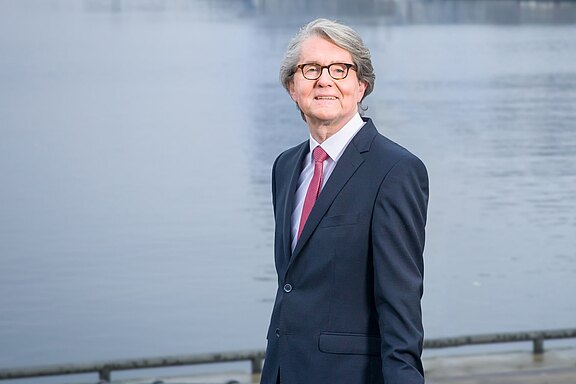 Porträt von Uwe Schumacher, Vorstandsvorsitzender der DOMCURA, an der Kieler Hörn-Promenade.
